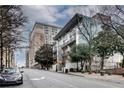 Contemporary condo building situated on a street with mature trees and nearby hotel at 33 Ponce De Leon Ne Ave # 203, Atlanta, GA 30308