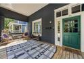 Inviting front porch with wooden floor, comfortable seating, and a patterned rug at 66 Howell Ne St, Atlanta, GA 30312