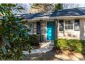 Close-up of the home's entrance, featuring a turquoise door with black decorative supports and manicured bushes at 3448 Montreal Way, Tucker, GA 30084