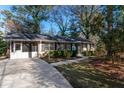 Ranch-style home with attached screened porch, driveway, manicured landscaping and blue front door at 3448 Montreal Way, Tucker, GA 30084