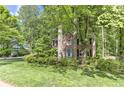 Charming brick two-story home nestled among mature trees, offering verdant landscaping and a serene wooded backdrop at 4259 Arbor Club Dr, Marietta, GA 30066