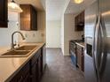 Galley kitchen view with stainless steel refrigerator, brown cabinetry, and double sink basin at 1173 Brockdell Ct, Norcross, GA 30093