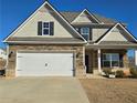 Two-story house with stone accents and a three-car garage at 1455 Weeping Tree Cir, Auburn, GA 30011