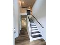 Bright foyer with wood flooring, white walls, and a staircase with dark wood railings at 4405 Belcamp Rd, Fairburn, GA 30213