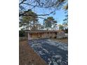 Front view of brick ranch house with attached carport and landscaping at 5737 Lorraine Dr, Stone Mountain, GA 30087