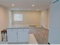 Bright living room with fresh paint, light-colored flooring, modern lighting, and a kitchen island with a granite countertop at 1421 Eason St, Atlanta, GA 30314