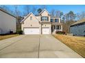 Inviting two-story home boasts a long driveway and two-car garage, set against a backdrop of trees and clear skies at 2536 Dayview Ln, Atlanta, GA 30331