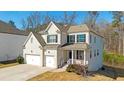 Classic two-story home featuring a two-car garage, covered porch, and manicured lawn in a suburban setting at 2536 Dayview Ln, Atlanta, GA 30331