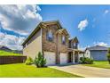 Two story house with a two-car garage, brick and siding exterior, and a green lawn at 8051 Nolan Trl, Snellville, GA 30039