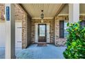 Covered front porch featuring a dark wood front door with sidelights and house numbers at 8051 Nolan Trl, Snellville, GA 30039