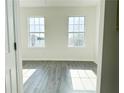 Bedroom with two windows letting in natural light, light-colored walls, and gray wood-look floors at 1752 Sw Pryor Sw Rd # 105, Atlanta, GA 30315