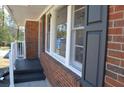 Close up of home with brickwork, dark shutters, and a small covered porch with white railing at 2773 Fairlane Dr, Atlanta, GA 30354