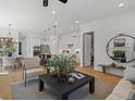 Open-concept living room showcasing hardwood floors, recessed lighting, and seamless transition to the modern kitchen at 401 Nettle Ct, Woodstock, GA 30188