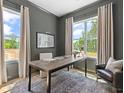 Bright study with neutral walls, large windows, modern desk, and comfortable chair, perfect for a home office at 401 Nettle Ct, Woodstock, GA 30188