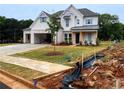 New home boasts white brick and siding, complemented by a manicured lawn and newly installed sidewalk at 679 Crest Line Trl, Powder Springs, GA 30127