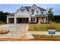 New construction home features a light brick facade, a two-car garage, and beautifully landscaped front yard at 679 Crest Line Trl, Powder Springs, GA 30127