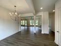 Open-concept living and dining area with modern light fixture and wood flooring throughout at 679 Crest Line Trl, Powder Springs, GA 30127