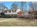 Ranch style home with a brick and beige exterior, landscaping, and a walkway leading to the entrance at 1519 Carnaby Ct, Dunwoody, GA 30338