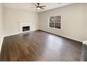 Spacious living room featuring dark hardwood floors and a fireplace at 7045 Treeline Dr, Cumming, GA 30028