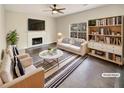 Virtually staged living room with fireplace and built-in shelving at 7045 Treeline Dr, Cumming, GA 30028