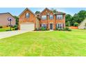 Spacious two-story brick home with a lush green lawn and attached two-car garage at 600 Beckenham Walk Dr, Dacula, GA 30019