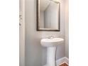 Small, updated powder room with pedestal sink and framed mirror at 4367 Favored Way, Union City, GA 30291