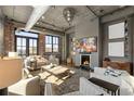 Comfortable living room featuring a fireplace, exposed brick, and ample seating at 3235 Roswell Ne Rd # 617, Atlanta, GA 30305