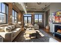 Stylish living room with exposed brick, fireplace, and large windows offering plenty of natural light at 3235 Roswell Ne Rd # 617, Atlanta, GA 30305