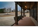 Covered front porch with wooden floors, framed by classic columns and dark shutters at 6310 Talking Tree Ct, Cumming, GA 30028