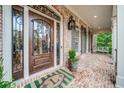 Close-up of the front porch, showing the decorative ironwork on the front door and brick flooring at 9070 Huntcliff Trce, Sandy Springs, GA 30350