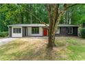 Charming one-story home with a brick and siding exterior, lush lawn and mature trees, perfect for nature lovers at 1428 Muirfield Dr, Stone Mountain, GA 30088