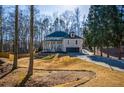 Two-story brick home with front porch and attached garage, nestled amongst mature trees at 1496 Sweet Bottom Sw Cir, Marietta, GA 30064