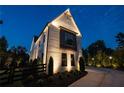Striking exterior view of a white brick home with black-framed windows at twilight at 100 Chateau Pl, Woodstock, GA 30188