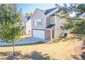 Two-story house with light beige vinyl siding, stone accents, and a two-car garage at 239 Dove Pl, Social Circle, GA 30025