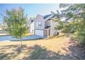 Two-story house with light beige vinyl siding, stone accents, and a two-car garage at 239 Dove Pl, Social Circle, GA 30025