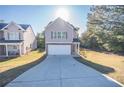 Two-story house with light beige vinyl siding, stone accents, and a two-car garage at 239 Dove Pl, Social Circle, GA 30025
