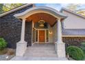 Inviting front entrance featuring a unique portico, stone accents, and modern lighting at 4070 Whitewater Creek Nw Rd, Atlanta, GA 30327