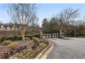 Gated community entrance with stone pillars, landscaping, and a secure entry system offers exclusivity and peace of mind at 5021 Heatherwood Ct, Roswell, GA 30075