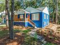 Cute blue house with orange door, stone path and wood accents at 1565 Ocala Sw Ave, Atlanta, GA 30311
