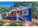 Blue house with white trim, orange door and wood details at 1565 Ocala Sw Ave, Atlanta, GA 30311