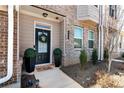 Welcoming townhome entrance with a wreath on the door, manicured greenery, and outdoor lighting at 532 Sonata Walk, Marietta, GA 30067