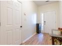 Welcoming entryway featuring wood-look floors, a sleek cabinet, and a modern door with sidelight for natural light at 1605 Signal Flag Way, Lawrenceville, GA 30043