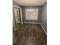 Simple dining room with dark wood floors and chandelier at 7533 Congregation St, Fairburn, GA 30213