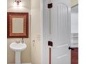 Charming bathroom with a pedestal sink, decorative mirror, and stylish wall sconce lighting at 275 Creek View Ln, Acworth, GA 30102