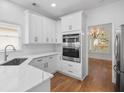 Well-lit kitchen featuring stainless steel appliances, white cabinets, and marble counters at 2224 Snug Ne Hbr, Marietta, GA 30066