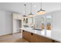 Bright kitchen with quartz island, pendant lighting, stainless appliances, and deck access at 2531 High Brow St # 41, Duluth, GA 30096