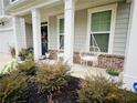 Inviting front porch featuring hanging basket chairs and beautifully landscaped bushes at 339 Garnet Dr, Acworth, GA 30101