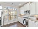 Modern kitchen with white cabinets, granite counters, and stainless steel appliances at 104 Laurel Crest Aly, Johns Creek, GA 30024