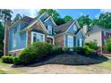 Charming two-story home with blue siding, brick accents, and mature landscaping at 3390 Vista Creek Dr, Dacula, GA 30019