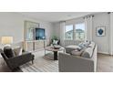 Spacious living room with gray sofa, large windows, and stylish decor at 3152 Birdsong Ave, Covington, GA 30016